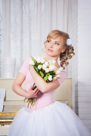 Beautiful ballerina with flowers in the studioの写真素材