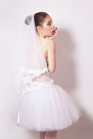 Portrait of a beautiful bride in veil, gray backgroundの写真素材