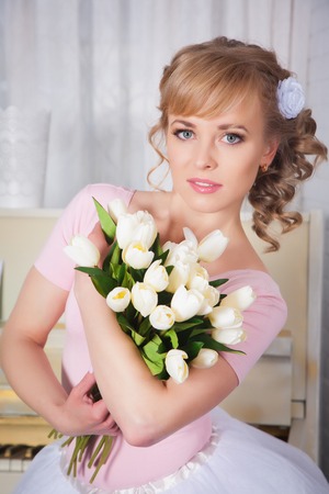 Beautiful woman with flowers in the studioの写真素材