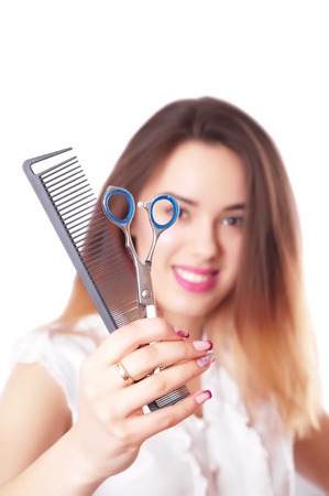 Cute woman hairdresser with scissors and combの写真素材