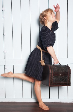 Pretty woman with a suitcase in his hand wavingの写真素材