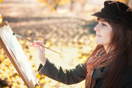Portrait of a young beautiful woman with a brush in her hand, outdoorsの写真素材