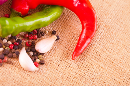 Red hot chili peppers with spice ingredients over burlap backgroundの写真素材