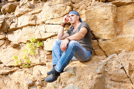 Man resting in the mountains sitting on the rockの写真素材