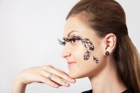 Beautiful woman with long eyelashes and face-art  in profile, close-upの写真素材