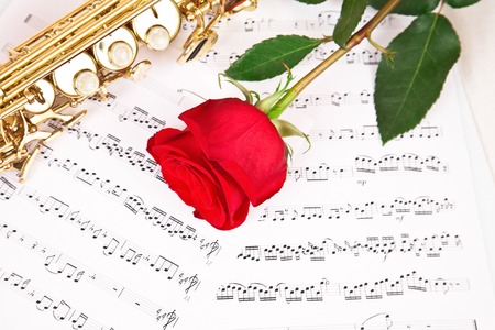 Musical notes and saxophone with red  roseの写真素材