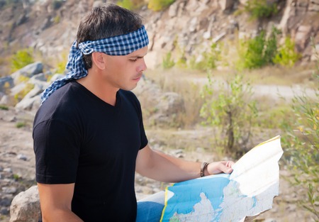 A young man outdoors looking at the mapの写真素材