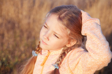 Portrait of a girl with pigtails closeup on a sunny day outdoorsの写真素材
