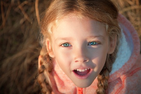 Portrait of a girl with pigtails closeup on a sunny day outdoorsの写真素材