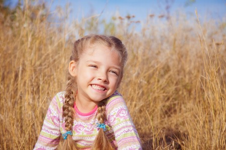 Portrait of a girl with pigtails closeup on a sunny day outdoorsの写真素材