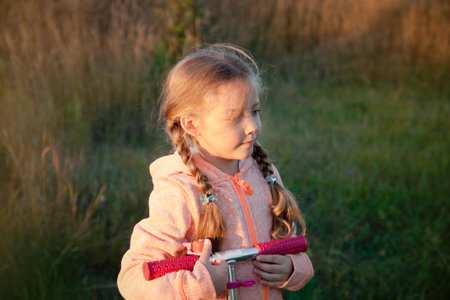 Beautiful girl driving scooter on rural road outdoor in natureの写真素材