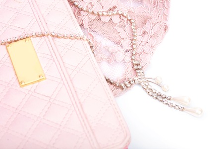 Pink clutch and jewelry with crystals on a white backgroundの写真素材