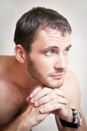 Portrait of thoughtful attractive man close up on a gray backgroundの写真素材