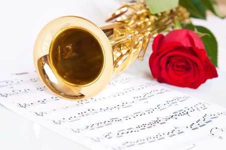 Musical notes and saxophone with red roseの写真素材