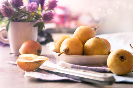 Still life with pears and flowers on the tableの写真素材