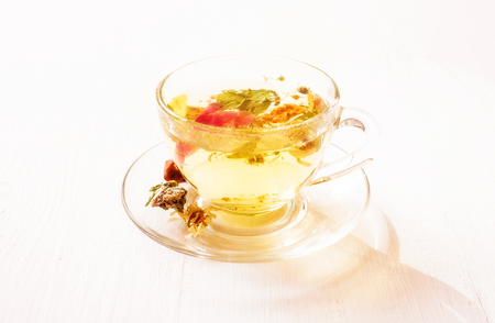Herbal tea in a transparent cup on the white table closeupの写真素材