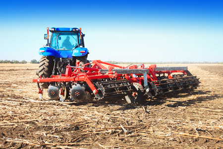 Blue tractor in the field on a sunny dayの写真素材