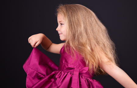 Portrait of a cute little girl in a pink dress in the studioの写真素材