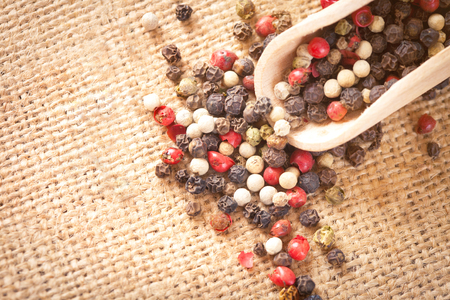 Red, white and black pepper in a wooden spoonの写真素材