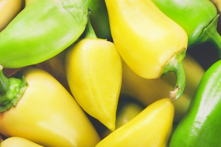 Background of yellow and green peppers, close-up viewの写真素材