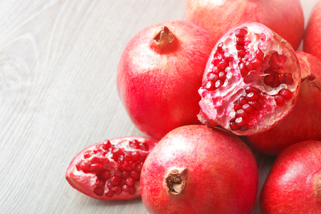 Close up sliced and whole pomegranate on a tableの写真素材