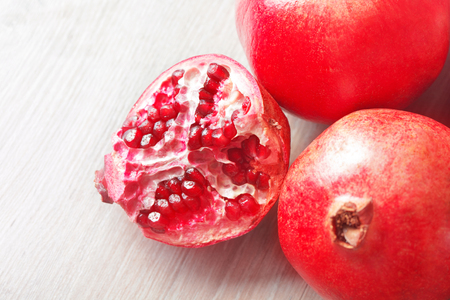 Close up sliced and whole pomegranate on a tableの写真素材