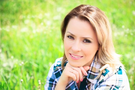 Portrait of a beautiful attractive woman in the grass on the natureの写真素材