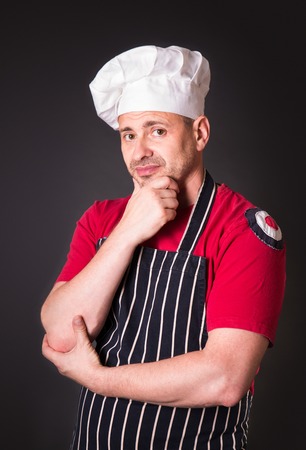 Portrait of a chef with a sad expression on his face in the studio on a black backgroundの写真素材
