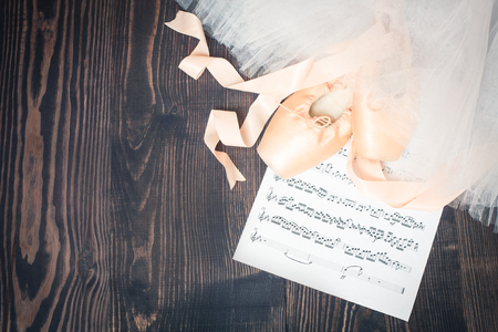 Ballet shoes, skirt and music sheet on a wooden backgroundの写真素材