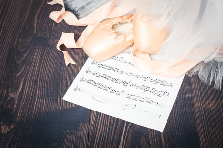 Ballet shoes, skirt and music sheet on a wooden backgroundの写真素材