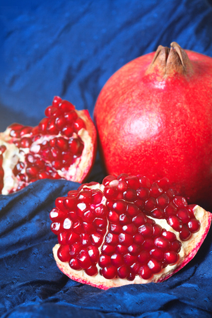 Juicy ripe pomegranates on dark blue backgroundの写真素材
