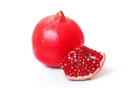 Fresh whole pomegranate and pieces on a white backgroundの写真素材