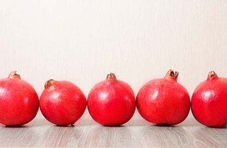 Several ripe pomegranates in a row on the tableの写真素材