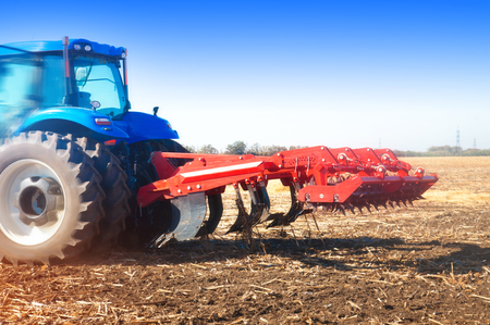 Tractor in a field in autumn sunny dayの写真素材
