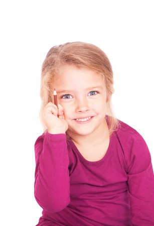 Portrait of a cute little girl with pencil in hand on a white background in studioの写真素材