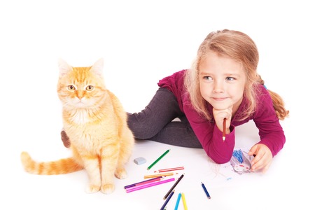 Little cute girl with colored pencils and red cat lying on the floor on a white backgroundの写真素材