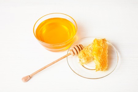 Honey with a wooden spoon on a white tableの写真素材