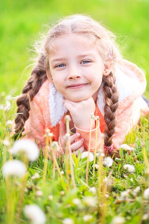 Cute little girl on the meadow in bright summer dayの写真素材