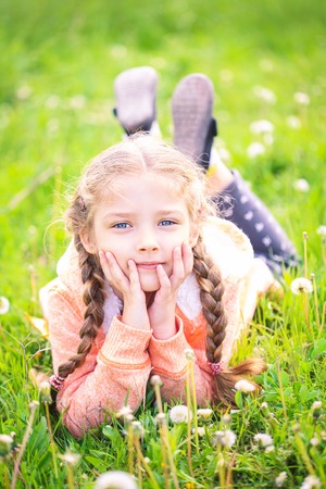 Cute little girl on the meadow in bright summer dayの写真素材