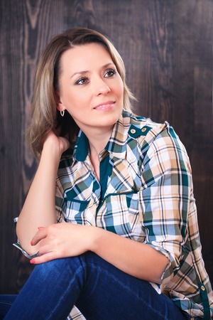 Portrait of a beautiful young woman on a wooden backgroundの写真素材