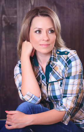 Portrait of a beautiful young woman on a wooden backgroundの写真素材