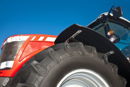 Red tractor against the clear blue sky close-upの写真素材