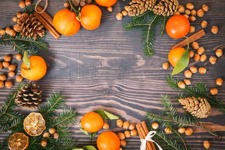 Wooden background with tangerines, fir branches, nuts cinnamonの写真素材