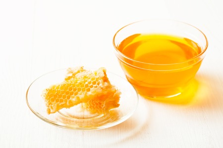 Honey and honeycomb on a white tableの写真素材