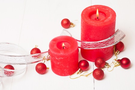 Red candles and Christmas decorations on a white backgroundの写真素材