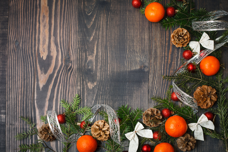 Red Christmas balls, fir branches and tangerines on a wooden backgroundの写真素材