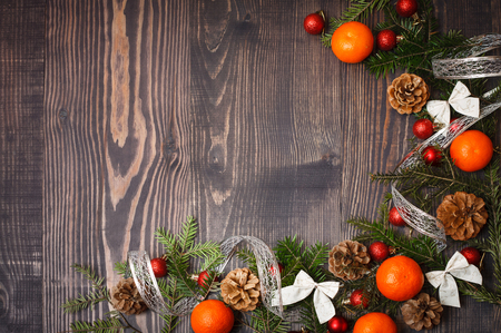 Red Christmas balls, fir branches and tangerines on a wooden backgroundの写真素材