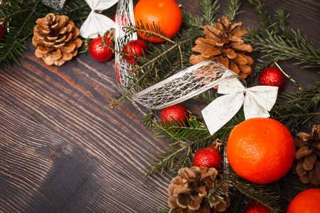 Red Christmas balls, fir branches and tangerines on a wooden tableの写真素材