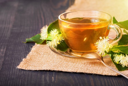 Linden tea on a wooden table in a glass cup. Flower tea, herbal medicine.の写真素材