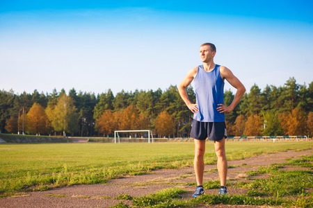 Young athletic man standing at the old stadium.の写真素材
